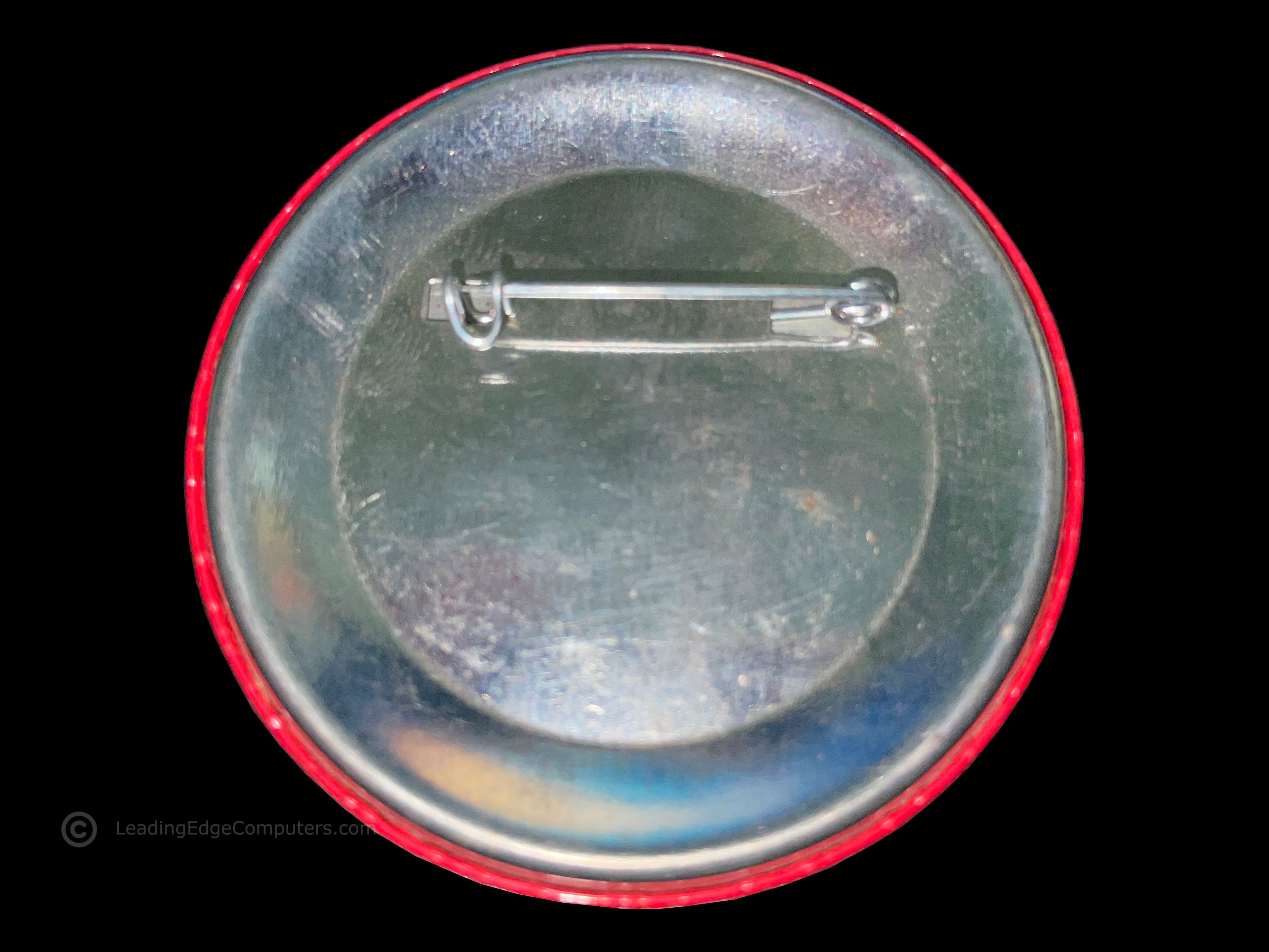 the rear of the model d promotional button showing the safety pin located at the top of the button